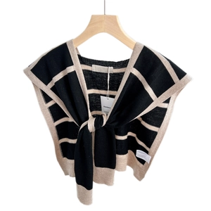 Striped knit shawl accessory in black and cream with front tie-knot on a wooden hanger