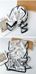 Detail of lightweight white scarf with black bird print and delicate edge stitching