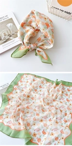 Detail eines Blumen-Leinentuchs mit orangen Blüten und grünem Wellenrand-Design