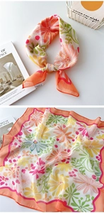 Detail eines geblümten Polyester-Schals mit orangefarbener Naht und bunten Mustern