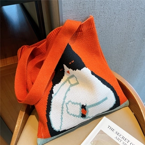 Chic orange knitted tote bag featuring a cute black and white cat pattern on a chair