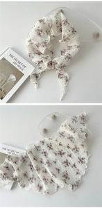Macro detail of pleated floral triangle scarf with purple flowers on ivory fabric