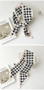 Détail d'un foulard étroit en soie à motif pied-de-poule noué sur un panier blanc