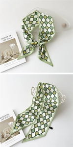 Détail d'un foulard en soie à carreaux vert et blanc avec motifs de cœurs jaunes