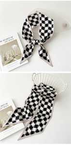 Détail d'un foulard en soie à damier noir et blanc avec une bordure couleur lavande