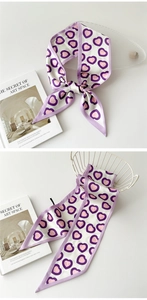 Détail d'un foulard en soie avec motifs de cœurs violets pour le cou et les sacs