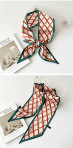 Détail d'un foulard étroit en soie à motif de treillis rouge et vert en plusieurs styles