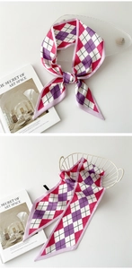 Détail d'un foulard étroit en soie à motif losanges rose et violet noué sur un panier