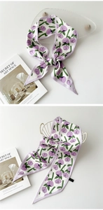 Détail d'un foulard étroit en soie à imprimé tulipes mauves sur un panier décoratif
