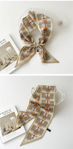 Détail d'un foulard étroit en soie avec motif à carreaux vintage et texture satinée lisse