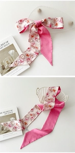 Détail d'une écharpe longue en soie avec motifs floraux et doublure rose satinée