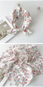 Détail d'un foulard en coton avec d'élégants motifs floraux rouges et bleus fins