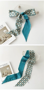 Détail d'un foulard étroit en soie avec motifs géométriques vintage et calligraphie
