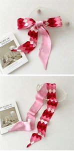 Détail d'un foulard en satin à damier rose noué en boucle avec texte 'as you wish'