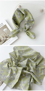 Détail d'un foulard en lin de coton vert clair avec imprimé marguerites et drapé doux