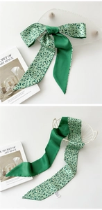 Détail d'un foulard mince vert foncé avec motif léopard cœur et nœud élégant stylisé