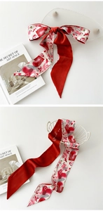Détail d'un foulard en soie à motif cœurs et inscription 'as your love' sur tissu satiné