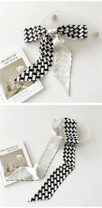 Détail d'un élégant foulard ruban en soie noir et blanc avec imprimés et décors artistiques