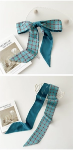 Détail d'un foulard Twilly bleu sarcelle avec motifs rétro et lettrage artistique blanc