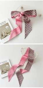 Gros plan d'un foulard en soie rose à motif géométrique et finition satinée