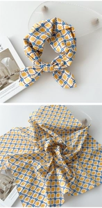 Détail d'un foulard en coton et lin jaune avec fleurs bleues et motifs losanges