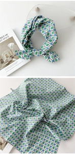 Vue détaillée d'un foulard en coton et lin vert à losanges avec un motif floral bleu
