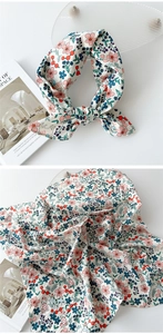 Détail d'un foulard carré en coton et lin à fleurs avec imprimé chiot et texture