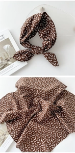 Détails d'un foulard en coton et lin marron foncé avec coutures fines et motif floral
