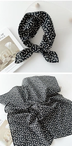 Texture détaillée d'un foulard noir en coton et lin avec motif petites fleurs blanches