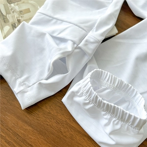 White sun protection arm sleeves with thumb hole and elastic cuff on wooden background