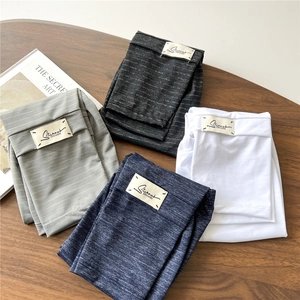 Folded solid color arm sleeves in grey black navy and white on wooden surface