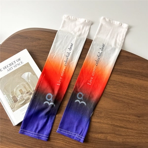 Detail of gradient sun protection arm sleeves with colorful print on a wooden desk