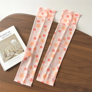 Close-up of pink floral cooling sun sleeves with The Best Wishes text on a wooden table