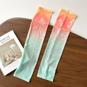 Detail of gradient ice silk sun sleeves with butterfly print on a wooden tray