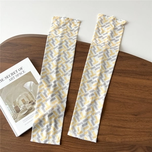 Flat lay of breathable ice sleeves with yellow and grey geometric patterns on wood