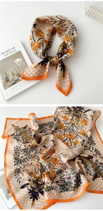Close-up of printed square scarf featuring orange lily flowers and checkerboard patterns