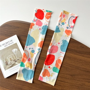 Detail view of white sun sleeves with colorful heart patterns and knit edge stitching