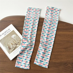 Detail of breathable cooling sleeves with pink and blue dot patterns on wooden tray