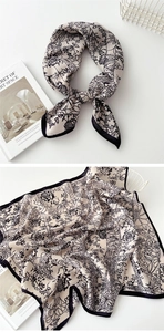 Detailed view of beige cotton-linen square scarf with black floral print and hemmed edges