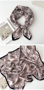 Detail of silk-feel square scarf featuring delicate pink floral patterns and black edges