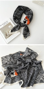 Detail view of cotton linen scarf showing orange abstract pattern and houndstooth texture
