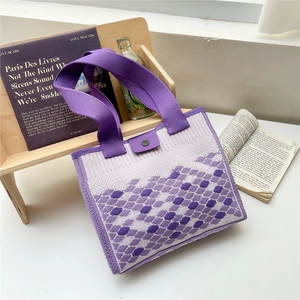Detail of purple knitted tote bag showing geometric patterns and black metal snap button