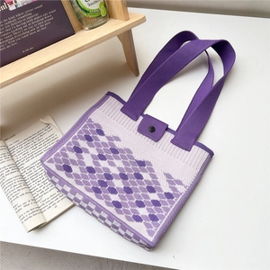 Detailed top view of purple diamond pattern knit tote bag on a white desk