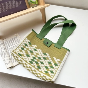 Close-up of diamond pattern knitted tote bag with button closure in soft green tones