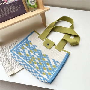 Detail of blue and green checkered knit tote bag with top button and sturdy strap