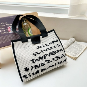 Minimalist knit tote bag in black and white with abstract letter pattern and button
