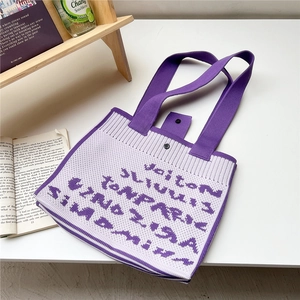 Detail of purple and white knit tote bag with thick texture and metal snap closure