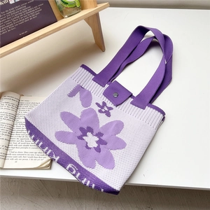 Detail of floral knit tote bag featuring purple flower pattern and magnetic snap closure