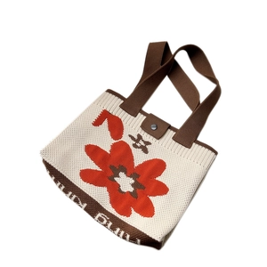 Knitted flower tote bag in cream and orange with brown handles and a metal snap closure