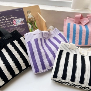 Chic striped knit tote bag with vertical patterns and snap button in a lifestyle setting